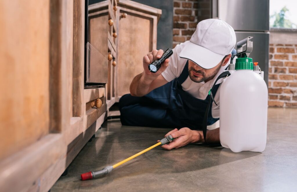 pest control worker lying on floor and spraying